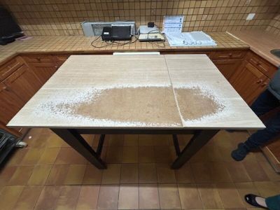 Une table de cuisine ordinaire en bois naturel à piètement à…