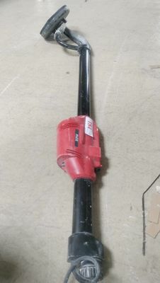 a red and black blower sitting on the floor in a garage