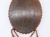 a close up of a wooden wall hanging with beads on it