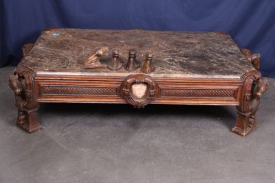 une table basse ancienne sculptée, surmontée d'un oiseau