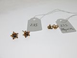trois boucles d'oreilles en or et une étiquette sur laquelle figure le prix