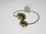 a gold bracelet with two skulls on it and a price tag