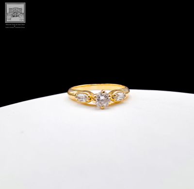 a gold ring with three diamonds on top of a white plate