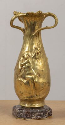 a gold vase sitting on top of a wooden table