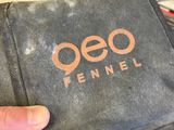 someone is holding a black bag with a logo on it