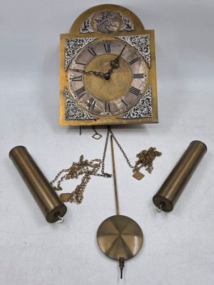 une horloge accrochée au mur et entourée d'une chaîne