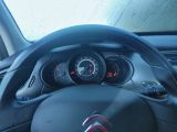 a steering wheel and dashboard of a car with a clock on it