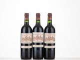 trois bouteilles de vin posées sur une table l'une à côté de l'autre