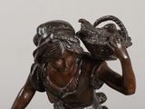 statue of a woman carrying a basket of fruit on her head