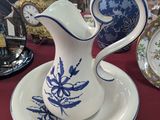 a blue and white pitcher and plate on a red table cloth