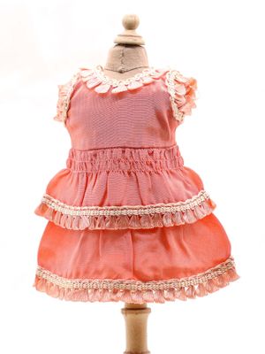 une robe rose posée sur un présentoir à mannequin, sur fond blanc