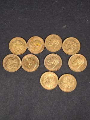quelques pièces d'or posées sur une surface noire, avec une pièce d'or au milieu