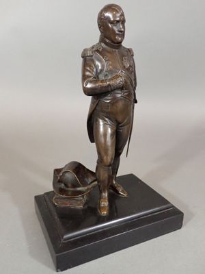 bronze statue of a man with a hat on a black base