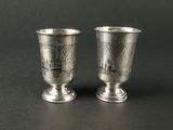 deux coupes en argent ornées de motifs sur un fond noir