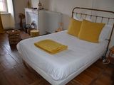 un lit blanc orné d'oreillers jaunes, dans une chambre