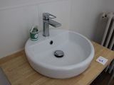 a white sink sitting on top of a wooden counter