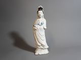 une statue de femme tenant une fleur à la main