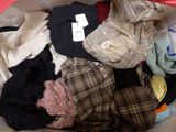 a pile of clothes in a basket with a tag on it