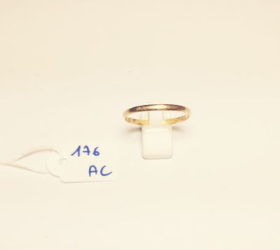 a gold ring on a white surface with a price tag