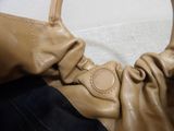 a tan purse with a knot on the handle