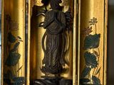 un écrin en or orné d'une statuette représentant une femme tenant une fleur