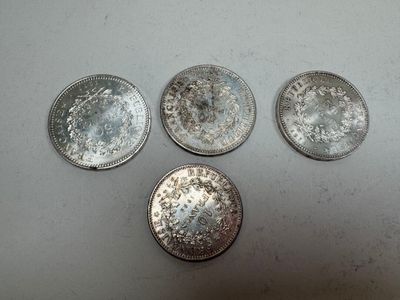 four silver coins sitting on top of a table next to each other