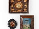 two framed pictures of a crucif and a clock on a wall