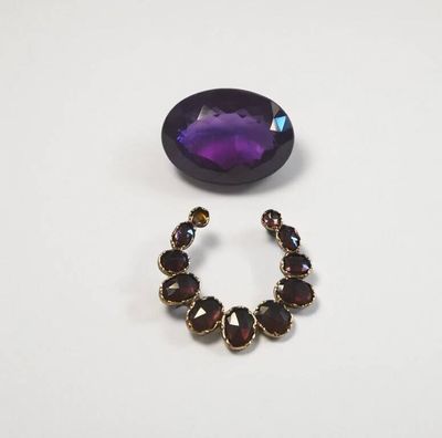 un gros plan sur une paire de boucles d'oreilles ornées d'une pierre violette