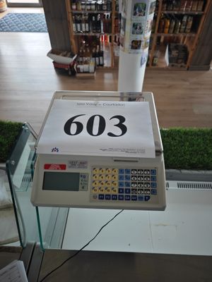 une caisse enregistreuse dans un magasin, sur laquelle est apposée une étiquette de prix