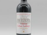 une bouteille de vin rouge posée sur une table blanche