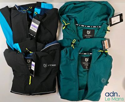 three pairs of jackets and pants sitting on top of a white table
