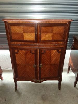 une image représentant une armoire en bois à deux portes et deux chaises