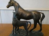 une statue en bronze représentant un cheval et son poulain, posée sur une table
