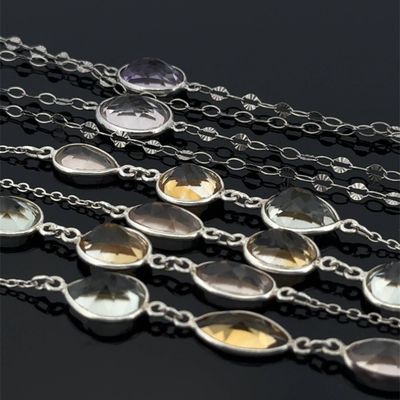 a close up of a bunch of necklaces on a black surface