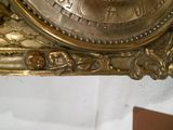 une horloge en or accrochée au mur de la pièce