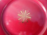 a red plate with a yellow flower on it