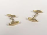 une paire de boutons de manchette en or sur fond blanc