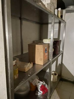 a metal shelf with boxes on it in a room