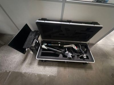 une mallette noire avec des outils à l'intérieur sur le sol