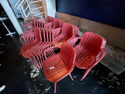 many red plastic chairs sitting in the middle of a room
