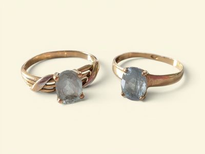 two gold rings with a blue stone on top of each other