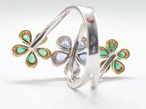 silver and gold plated ring with green and white enamel flowers