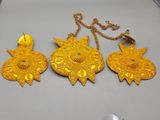 three pieces of gold jewelry are sitting on a table