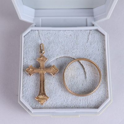 une bague et une croix dans une boîte posée sur une table