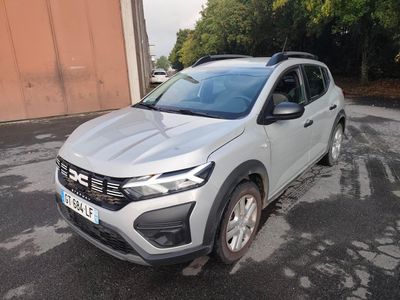 une voiture blanche garée dans un parking à côté d'un bâtiment