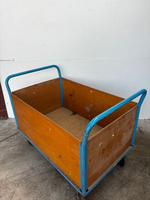 a wooden box with a blue handle on a dolly