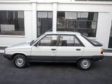 a small white car parked in front of a building