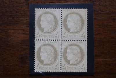 un gros plan sur quatre timbres posés sur une surface en bois