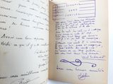 an open book with a handwritten page on it sitting on top of a table