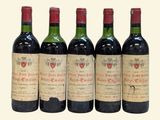 four bottles of wine are lined up on a white surface